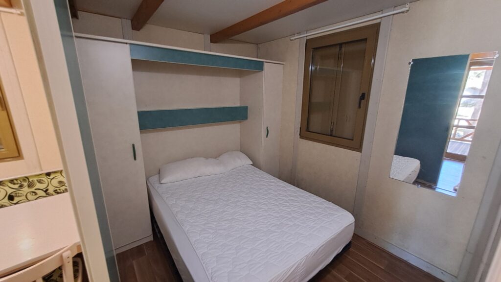 Dormitorio con cama de matrimonio en un bungalow del Camping Asolaze, Isaba