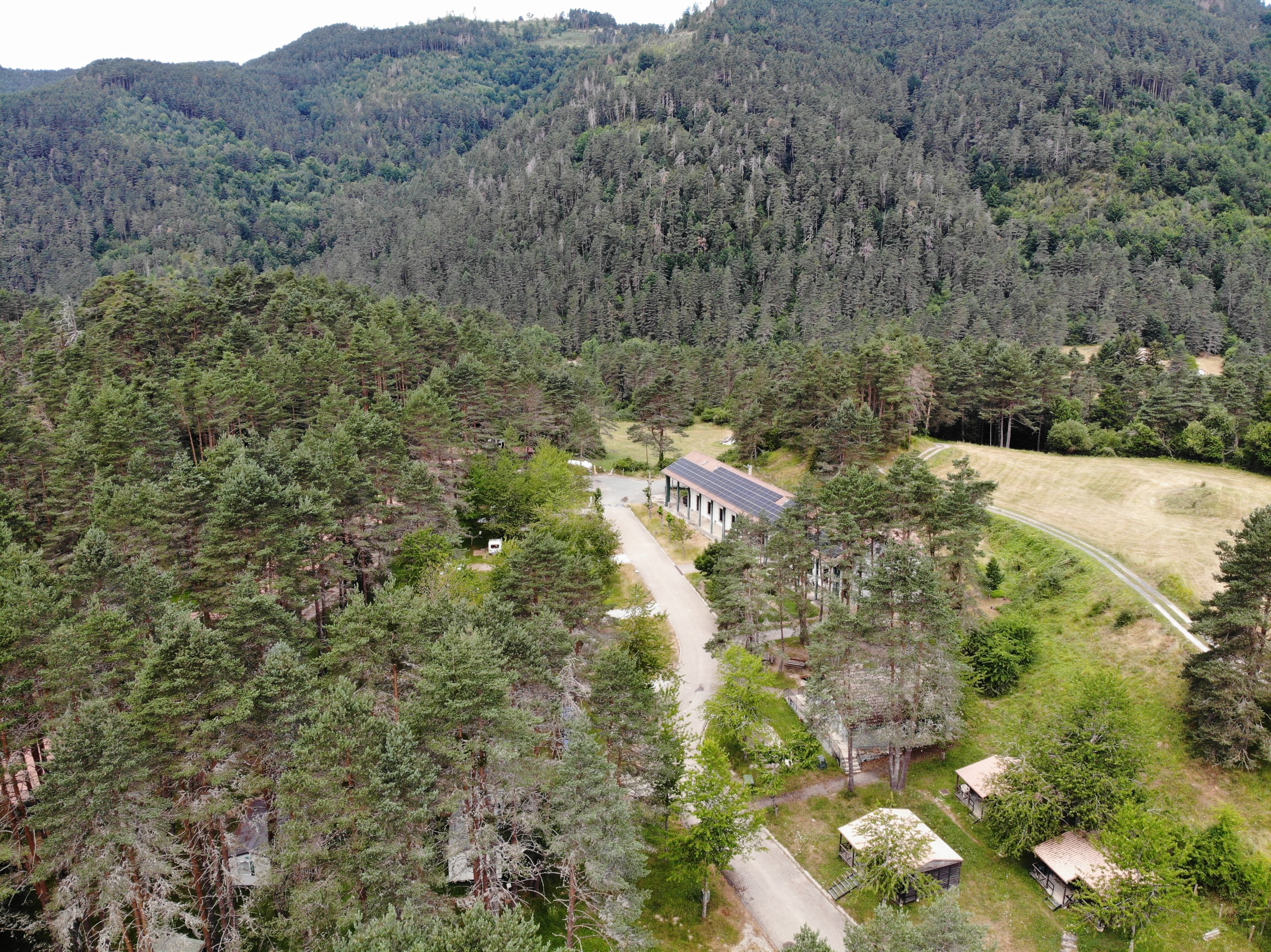 Vista aérea del Camping Asolaze rodeado de bosque y montañas en Isaba, Valle de Belagua