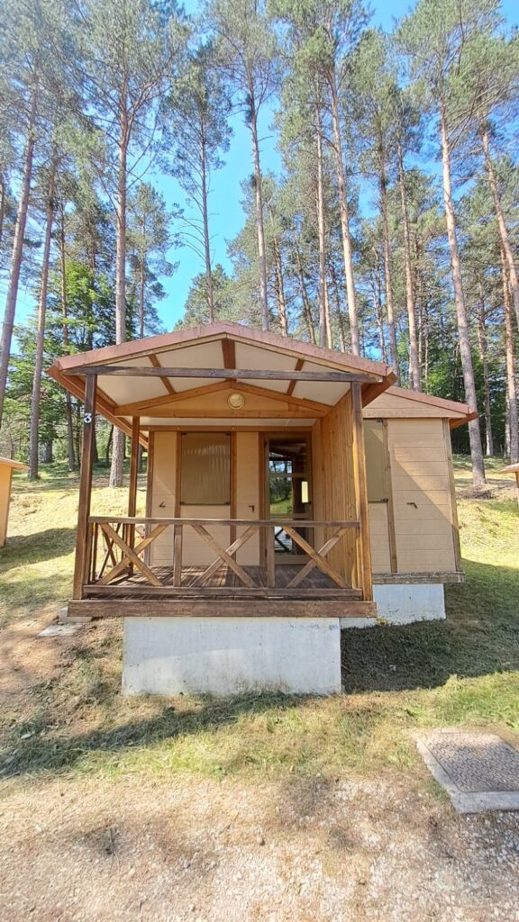 Bungalow de madera con porche en el Camping Asolaze, rodeado de un pinar en Isaba